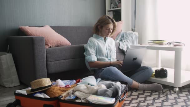 Nettes Mädchen tippt auf einem Laptop und macht sich bereit für einen Roadtrip — Stockvideo