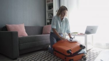 Seyahat eden kadın valizini topluyor yolculuk için hazırlanıyor, tatil için bavulları hazırlıyor.