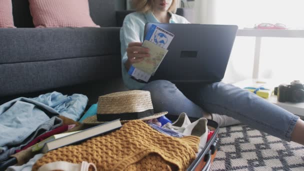 Девушка с билетами на отдых работает на ноутбуке — стоковое видео