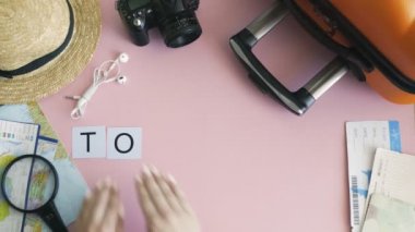 Üst görünüm eller pembe masa üzerinde uzanan kelime TOURISM
