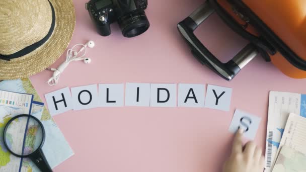 Üst görünüm eller pembe masa üzerinde uzanan kelime Holiday — Stok video