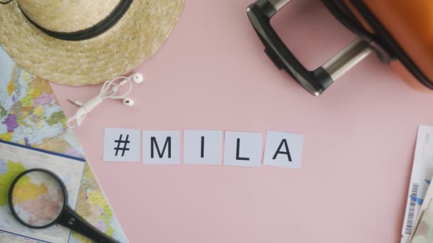 Manos de vista superior que ponen en la palabra de escritorio rosa MILAN — Vídeos de Stock