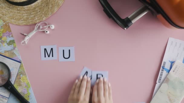 Góra widok ręce leżące na różowym biurku słowo MUMBAI — Wideo stockowe