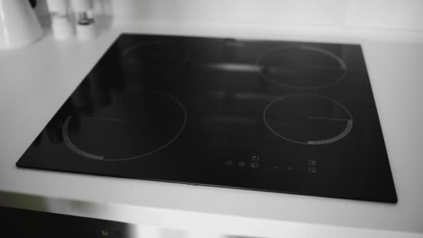 Gros plan d'une main féminine allumée sur une cuisinière à induction — Video