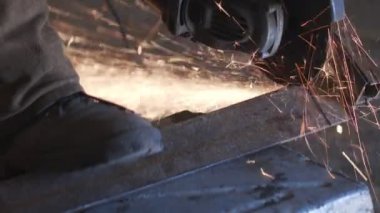 Adam dairesel testere ile çalışıyor. Sıcak metalin kıvılcımları.