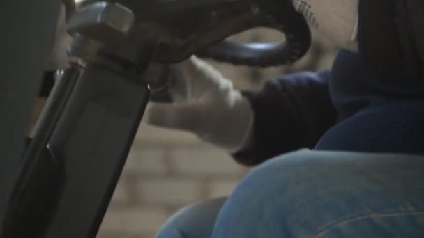 Pracownik w mundurze skręca kierownicą w kabinie ładowarki wózka widłowego ekstremalnie bliski widok. — Wideo stockowe