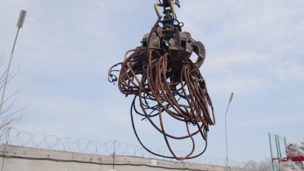 Maskin med mekanisk arm grabbing avfall från en hög på stadens deponi. — Stockvideo