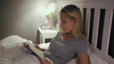 Gece iç çamaşırlı kadın kitap okumayı bitirdi ve uyumaya gitti.