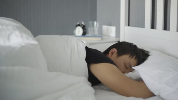 Gros plan de jeune homme asiatique couché et dormant dans le lit à la maison . — Video