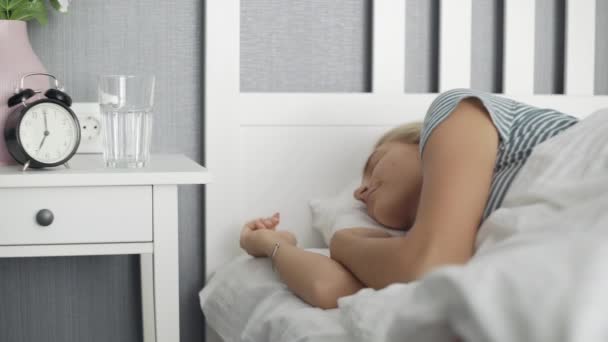 Mujer despertando en la cama blanca y agua potable en el dormitorio — Vídeo de stock