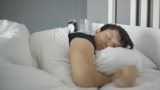 Close-up van jonge aziatische man liggen en slapen in het bed thuis. — Stockvideo
