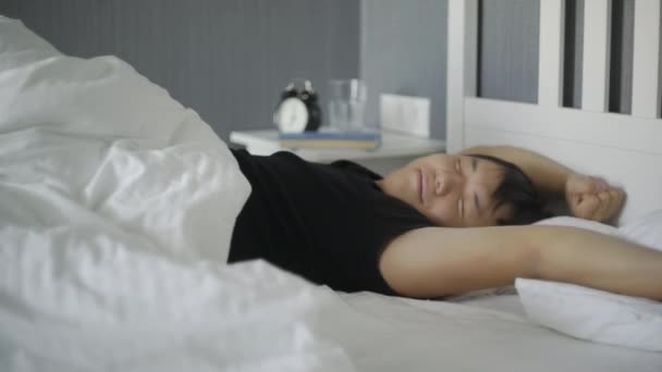 Giovane asiatico uomo wake up e stretching in il letto a casa . — Video Stock