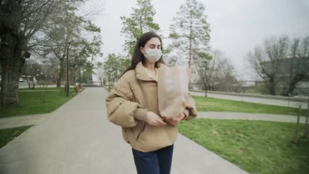 Giovane donna che indossa maschere protettive passeggiate con shopping bag durante Coronavirus COVID-19 Pandemia epidemica Covid-19 protezione coronavirus — Video Stock