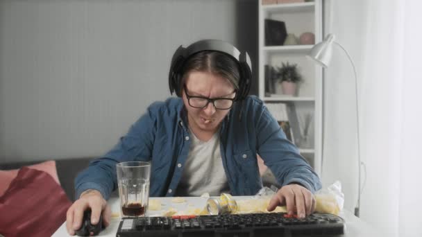 Koncentrerad ung man spelar TV-spel och kvävdes av chips — Stockvideo
