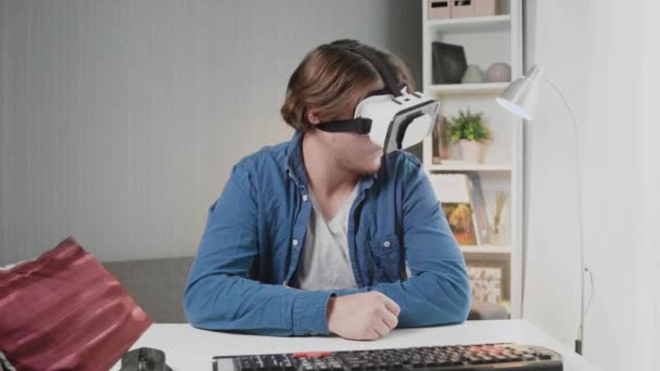 Молодой человек в очках виртуальной реальности в комнате — стоковое видео