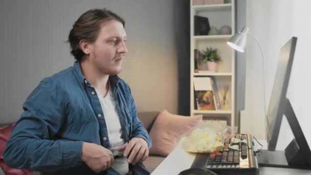 Jeune homme portant des lunettes et commencer à jouer à un jeu vidéo à la maison — Video