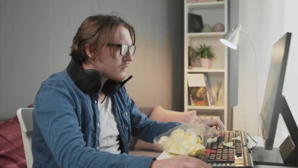 Video oyunu oynayan ve monitörün önünde oturan konsantre genç adamın yan görüntüsü — Stok video