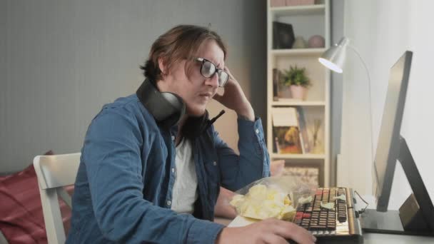 Vista lateral do jovem chateado jogando videogame e sentado na frente do monitor — Vídeo de Stock