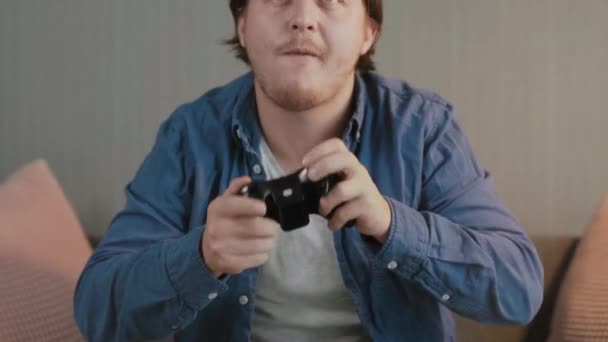 Close-up van jonge man spelen video games en op de bank in de avond — Stockvideo