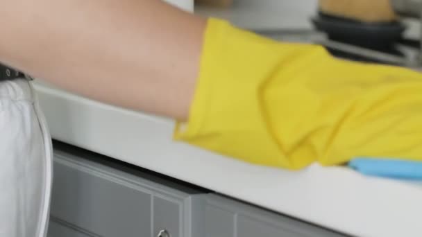 Hausfrau in gelben Handschuhen wäscht Tisch mit blauem Lappen und Spülmittel. — Stockvideo