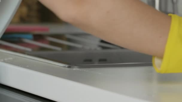 Huisvrouw in gele handschoenen was de tafel met oranje doek en wasmiddel. — Stockvideo