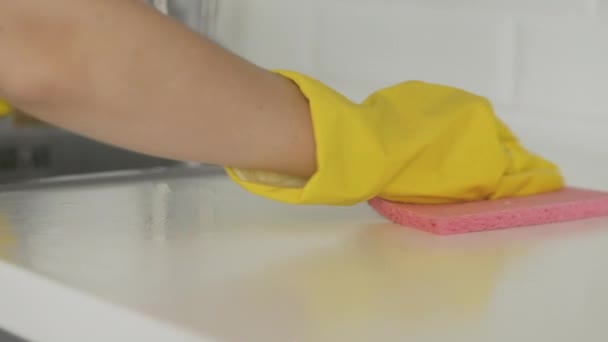 Huisvrouw in gele handschoenen schoonmaken van de tafel met roze doek — Stockvideo