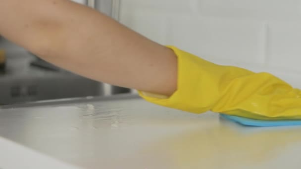 Femme au foyer en gants jaunes nettoyer la table avec chiffon bleu — Video