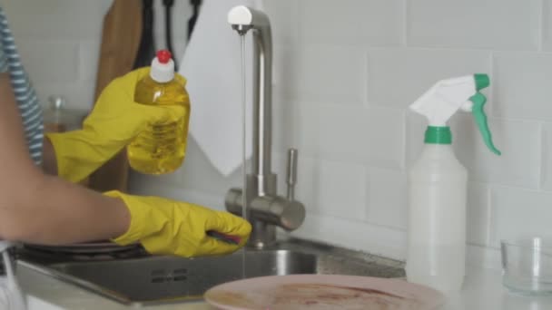 Женщина моет посуду в раковине на кухне — стоковое видео