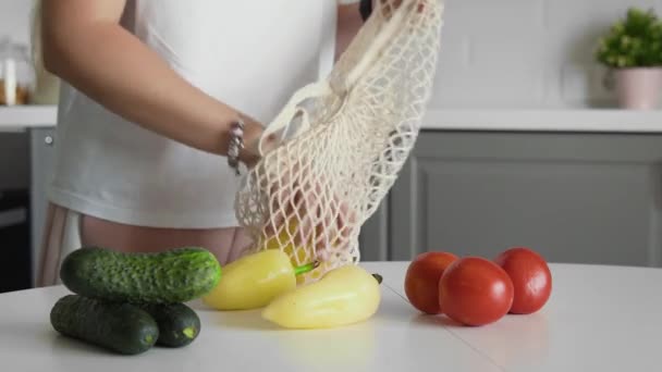 Cierre de casa de cero residuos y bolsa ecológica. Eco Shopping. Bolsas de comestibles reutilizables con pepinos, tomates, pimientos en la cocina sobre mesa de madera — Vídeos de Stock