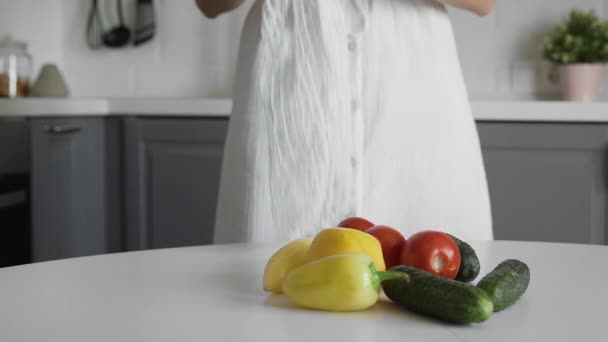 Großaufnahme einer jungen Frau legt Gemüse in eine durchsichtige Ökotüte. Null-Abfall-Konzept. Kein Plastikleben. Gesunder Lebensstil. Konzeptrecycling. — Stockvideo