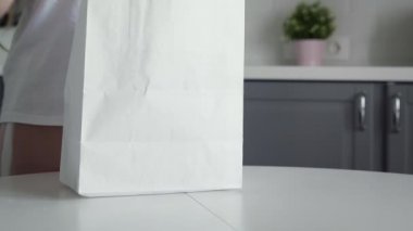 Kadının alışveriş poşetini açarken yanına ekmek, yulaf ezmesi, süt ve sebze al. Sıfır atık ev ve çevre torbası. Çevre Alışverişi.