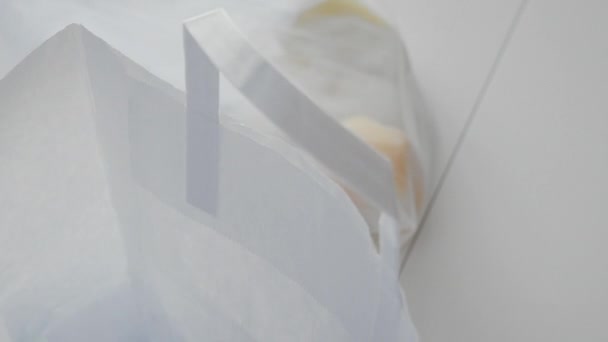 Close up of woman unpacking mesh shopping bag with cucumbers, tomatoes, peppers on the kitchen on wooden table. Zero waste home and eco bag. Eco Shopping. — Stock Video