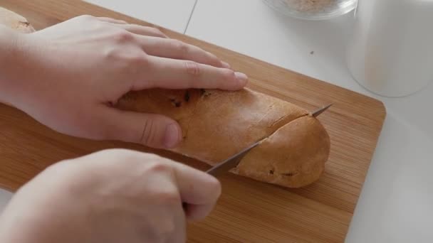 Primer plano de Vista superior de la mujer cortando una barra de pan con un cuchillo de pan — Vídeos de Stock