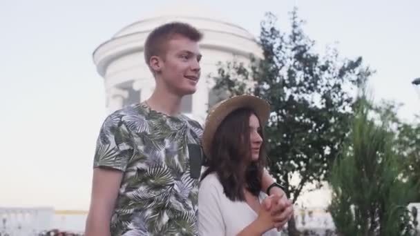 Jovem casal encantador caminha no parque de verão e fala — Vídeo de Stock