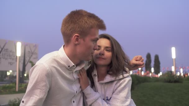 Young lovely couple sits and talks in the summer park in the evening — Stock Video