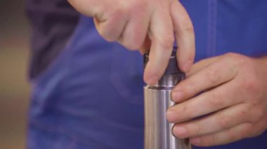 İşçi elleri fabrikada sondaj yapıyor.