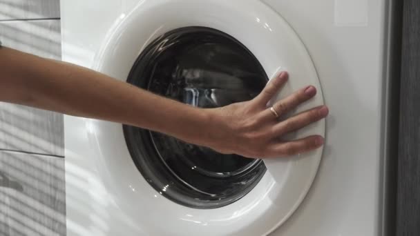 有结婚戒指的男性手从洗衣机上取下BLACK闭锁。装卸洗衣机。把衣服装上洗衣机.装上洗衣机.备洗衣物 — 图库视频影像
