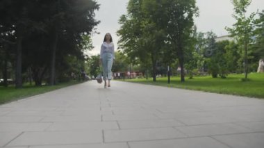 Dolly 'nin taşınması, elinde sebzelerle pamuk örgüsü alışveriş torbası tutması ve yaz parkında yürümesi. Sıfır atık.