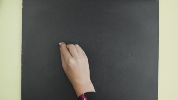 Top view. Woman writes the word OFFICE with chalk on a blackboard. — Stock Video