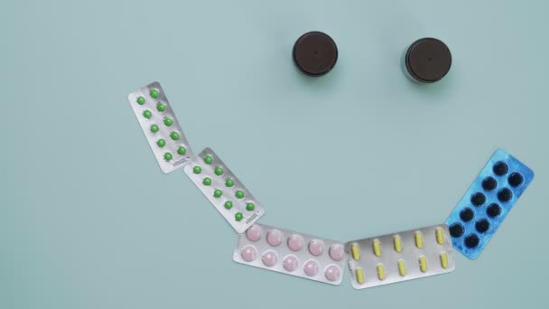 Vrouw maakt glimlach met pillen op de tafel — Stockvideo
