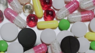 Beyaz arka plana düşen çok sayıda farklı türde hap.