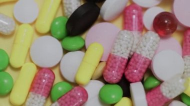 Beyaz arka plana düşen çok sayıda farklı türde hap.