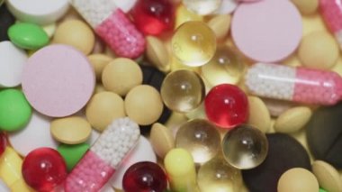 Beyaz arka plana düşen çok sayıda farklı türde hap.