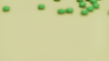 Sarı arka planda yeşil haplar.