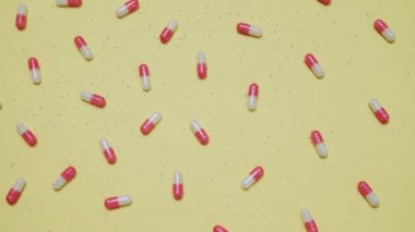 Sarı arka planda pembe ve beyaz haplar.