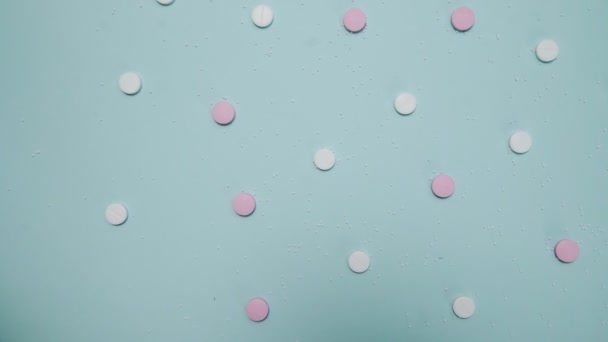 Pink and white pills on blue background — Stock Video