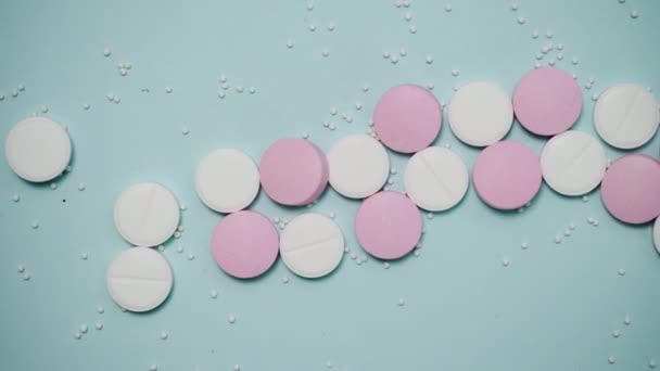 Rózsaszín és fehér tabletták a kék háttér — Stock videók