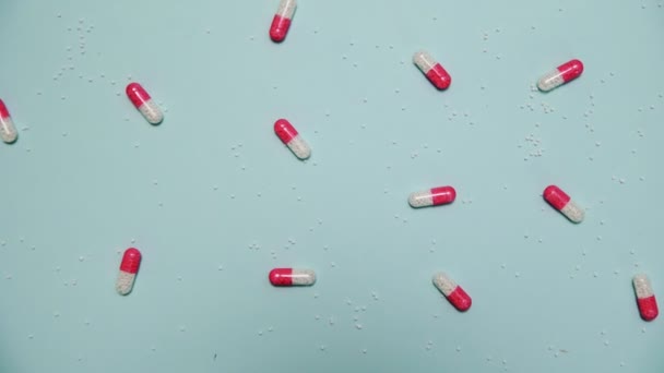Una gran cantidad de píldoras de color rosa y blanco sobre fondo azul — Vídeo de stock