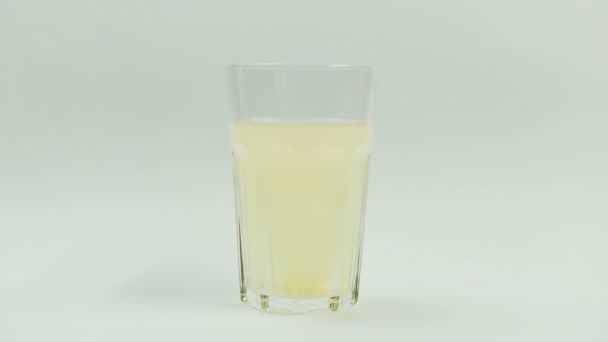 Píldora que cae en vaso con agua. comprimido efervescente aspirina. primer plano sobre fondo blanco — Vídeos de Stock