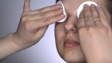 Makyajdan önce cilt kremi süren genç, güzel ve doğal bir kadının stüdyo portresi.